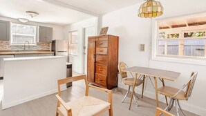 Eine moderne Küche mit einer zentralen Kochinsel, Holzschränken und einem Essbereich mit Tisch und Stühlen.