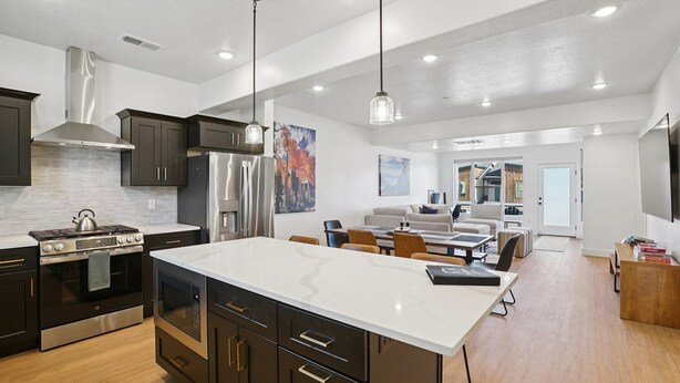 A modern kitchen with a large island, stainless steel appliances, and pendant lighting. - Risen Ranch by Crafty Casitas Hospitality (Mountain Green)