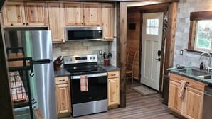 A kitchen with wooden cabinets, stainless steel appliances, a built-in oven, and a microwave.