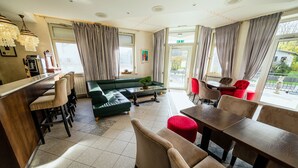 A hotel lobby with a bar, seating area, and a view of the outdoors.