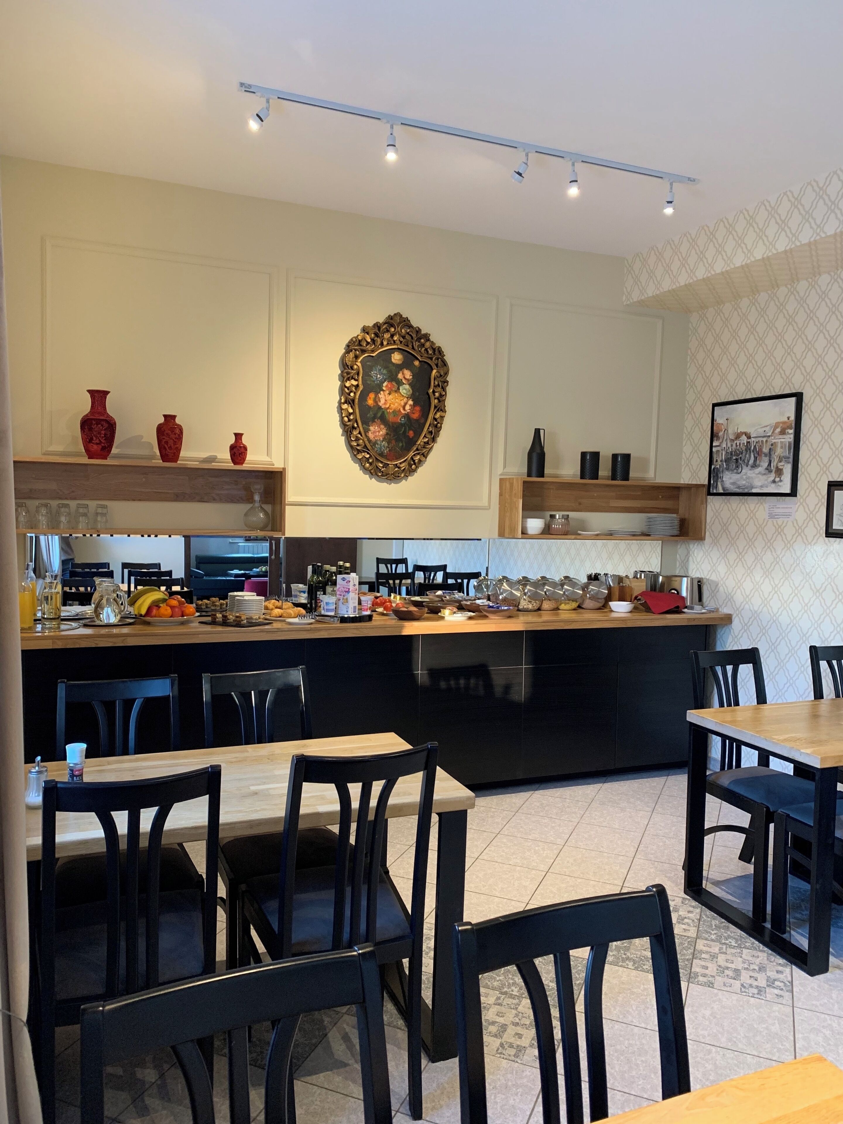 Een moderne keuken met een centraal eiland, zwarte stoelen en een eethoek.