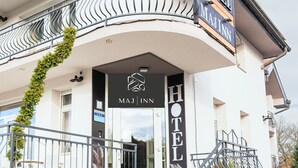 A hotel entrance with a sign reading 'MAJINN HOTEL,' a staircase, and a balcony with metal railings.
