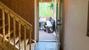 A wooden staircase leading to a balcony with a table and chairs, and a sign reading "ARCADE" on the wall. - The Carriage House / Walk to River & Lake, In Town (Grand Lake)