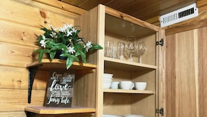 A wooden kitchen with a built-in shelf holding a plant and a sign, a toaster, and a kettle on the countertop. - The Red Bears Den / Walk to River & Lake, In Town (Grand Lake)