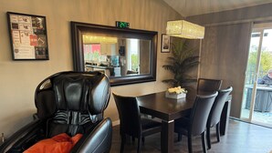 Ein moderner Essbereich mit einem schwarzen Ledersessel, einem Holztisch und einer Chandelüster.