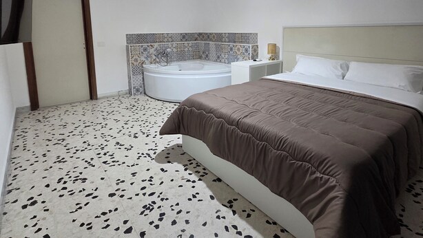 Ein Schlafzimmer mit Bett, Badewanne und Deckenleuchte.