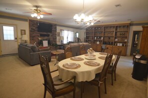 A dining area with a round table, chairs, and a chandelier.