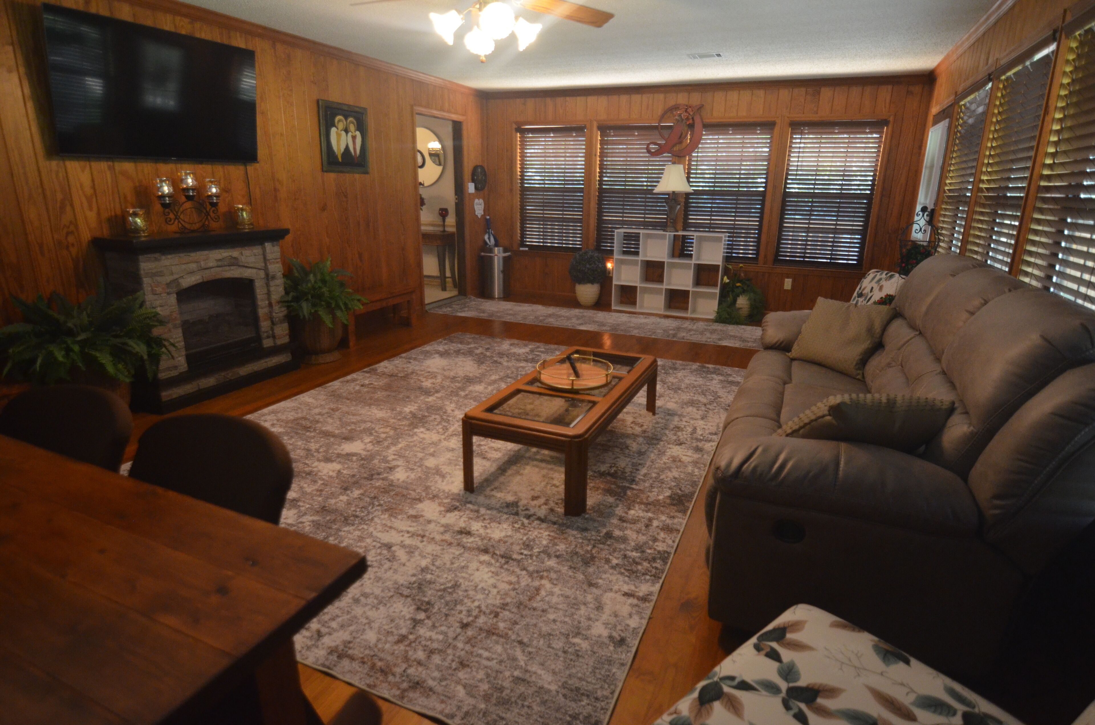 A living room with a fireplace, a sofa, a coffee table, and a television.