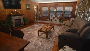A living room with a fireplace, a sofa, a coffee table, and a television.