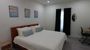 Une chambre à coucher avec un lit, un bureau et un ventilateur de plafond.