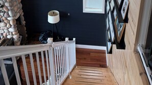 Eine Treppe mit Holzbalkonen, einem weißen Geländer und einer Steinmauer.