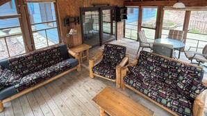 Une terrasse en bois avec un ensemble de canapés, une table et des chaises.