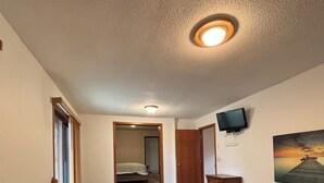 Une chambre d’hôtel équipée d’un jacuzzi, d’une télévision, d’un tableau et d’un escalier.
