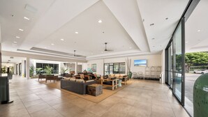 Eine geräumige Lobby mit hoher Decke, modernen Möbeln und großen Fenstern mit Blick ins Freie.