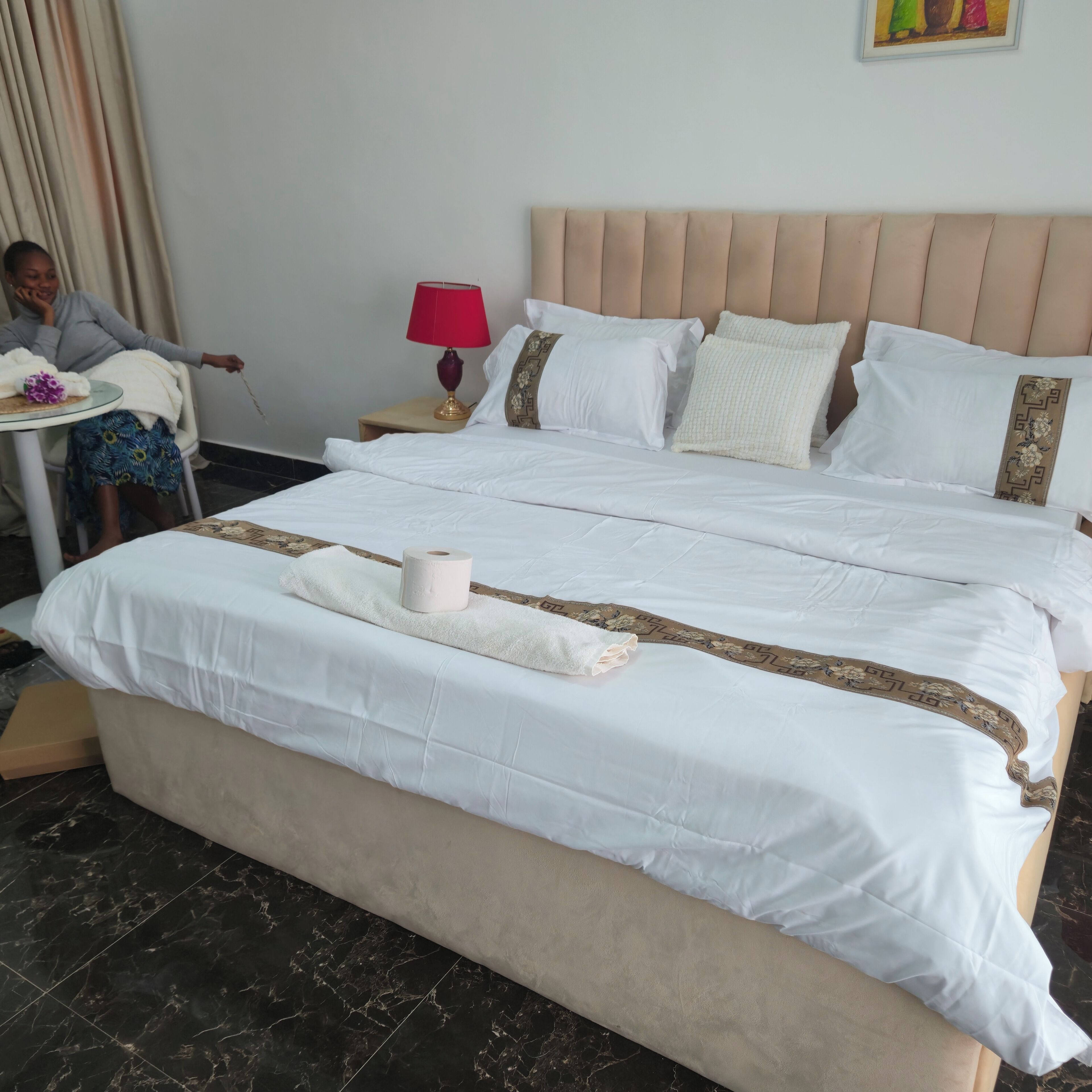 Une chambre d’hôtel avec un lit, une table de chevet, une lampe et une chaise.