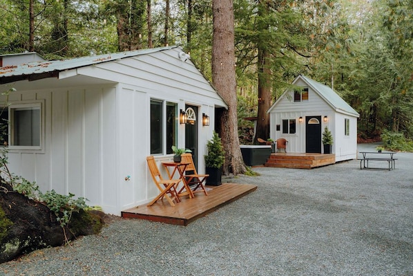 Two white cabins with wooden decks, surrounded by trees. - Holly Hideout (Gold Bar)