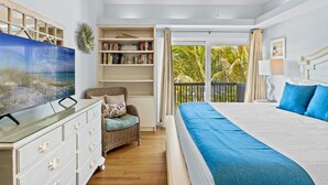 Une chambre à coucher avec un grand lit, une télévision, une bibliothèque et un fauteuil.