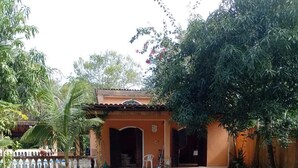 A house with a tiled roof, a small porch, and a well-maintained lawn. - Costa do Sol Condominium, 600m from Guaratuba beach, near Boraceia and Riviera. (Bertioga)