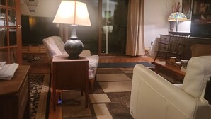 A living room with a sofa, a coffee table, a TV, and a lamp.