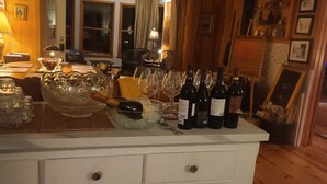 A wooden interior with a white bar area featuring wine bottles and glasses.