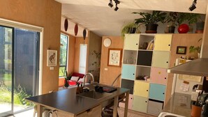 A modern kitchen with a central island, a built-in stove, and a variety of cabinets. - Funky Eco Pad - Innovative Design, with great indoor/outdoor flow.  Pet Friendly (Nelson)