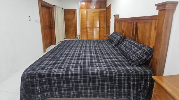 Ein Schlafzimmer mit einem Bett, einem Holz-Kopfteil und einem Kleiderschrank.