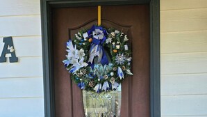 A brown door with a decorative wreath and a glass shield. - Salt & Sun Family Cottage - Boats & RVs welcome! 3 min Hurlburt; 12 min Eglin (Fort Walton Beach)
