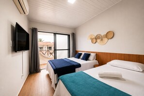 A hotel room with two beds, a TV, and a balcony with a view.