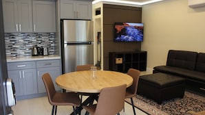 Una cocina moderna con armarios grises, un refrigerador de acero inoxidable y un salpicadero de azulejos.