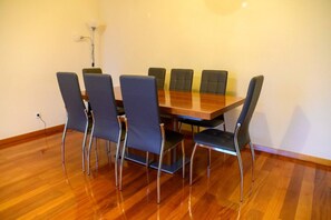 A conference room with a wooden table and six chairs with metal legs. - Gorete Apartment 3 by Mth (Funchal)