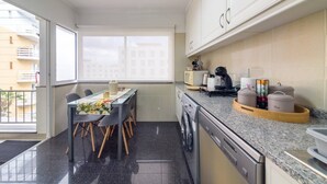 Una cuina moderna amb zona de menjador, grans finestres i vistes a la ciutat.