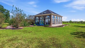 A single-story house with a brick exterior, large arched windows, and a blue door. - Space to Gather. Room to Relax. Bring Everyone—This Texas Ranch Has It All  (Huntsville)