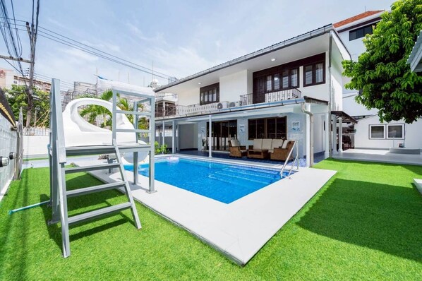 A modern house with a swimming pool, a diving board, and a covered patio area. - Greta Villa  Nakluea 18 (Pattaya)