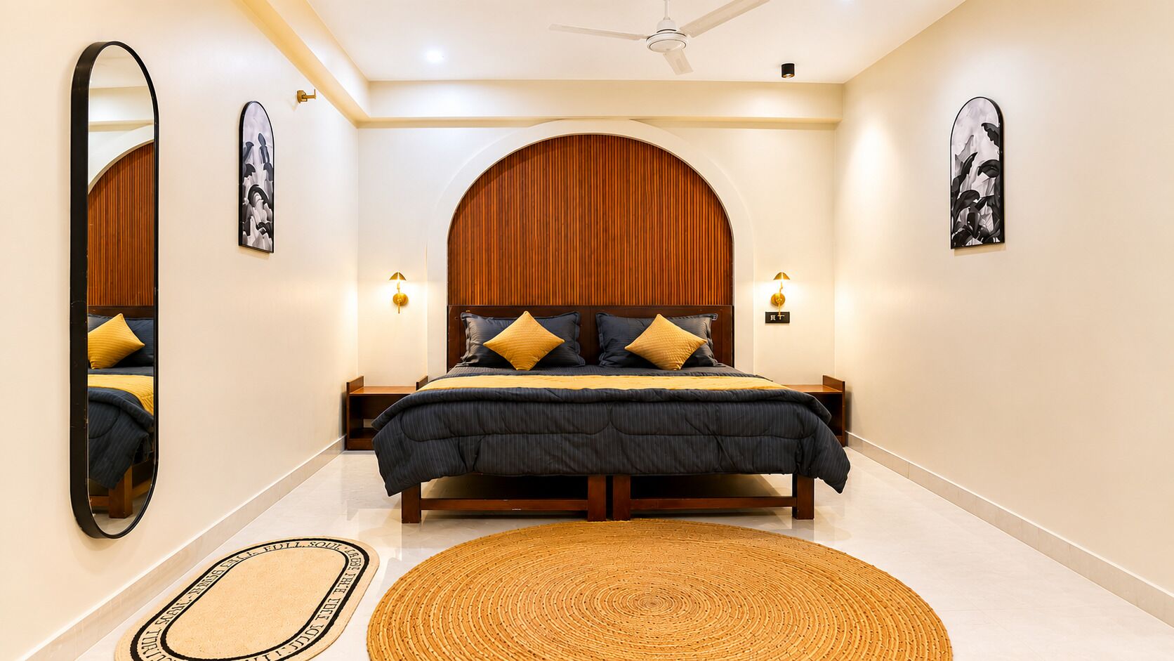 A bedroom with a bed, nightstands, a mirror, and artwork on the walls.