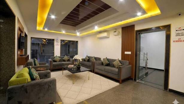 A modern lobby with sofas, a coffee table, and a glass door leading to a staircase. - Hotel Peridot Near Delhi Airport (New Delhi)
