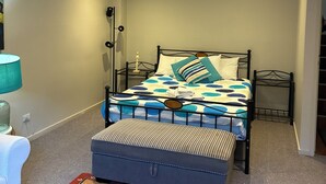 A bedroom with a bed, a nightstand, a lamp, and a suitcase. - Pearly shells central Nelson Bay. (Nelson Bay)