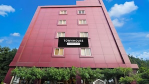Un immeuble à plusieurs étages portant une enseigne indiquant : « TOWNHOUSE, services d’entreprise ».