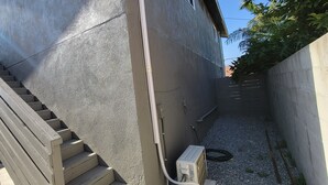 Una estrecha escalera exterior que conduce a un edificio con fachada de concreto.