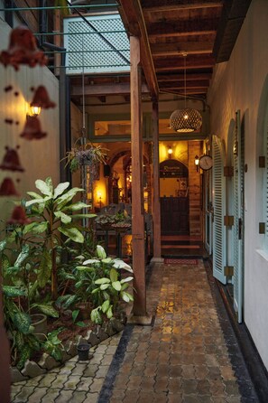 A narrow cobblestone pathway leading to a reception area with wooden beams and hanging plants. - Le Jardin du Fort - Boutique Hotel (Galle)