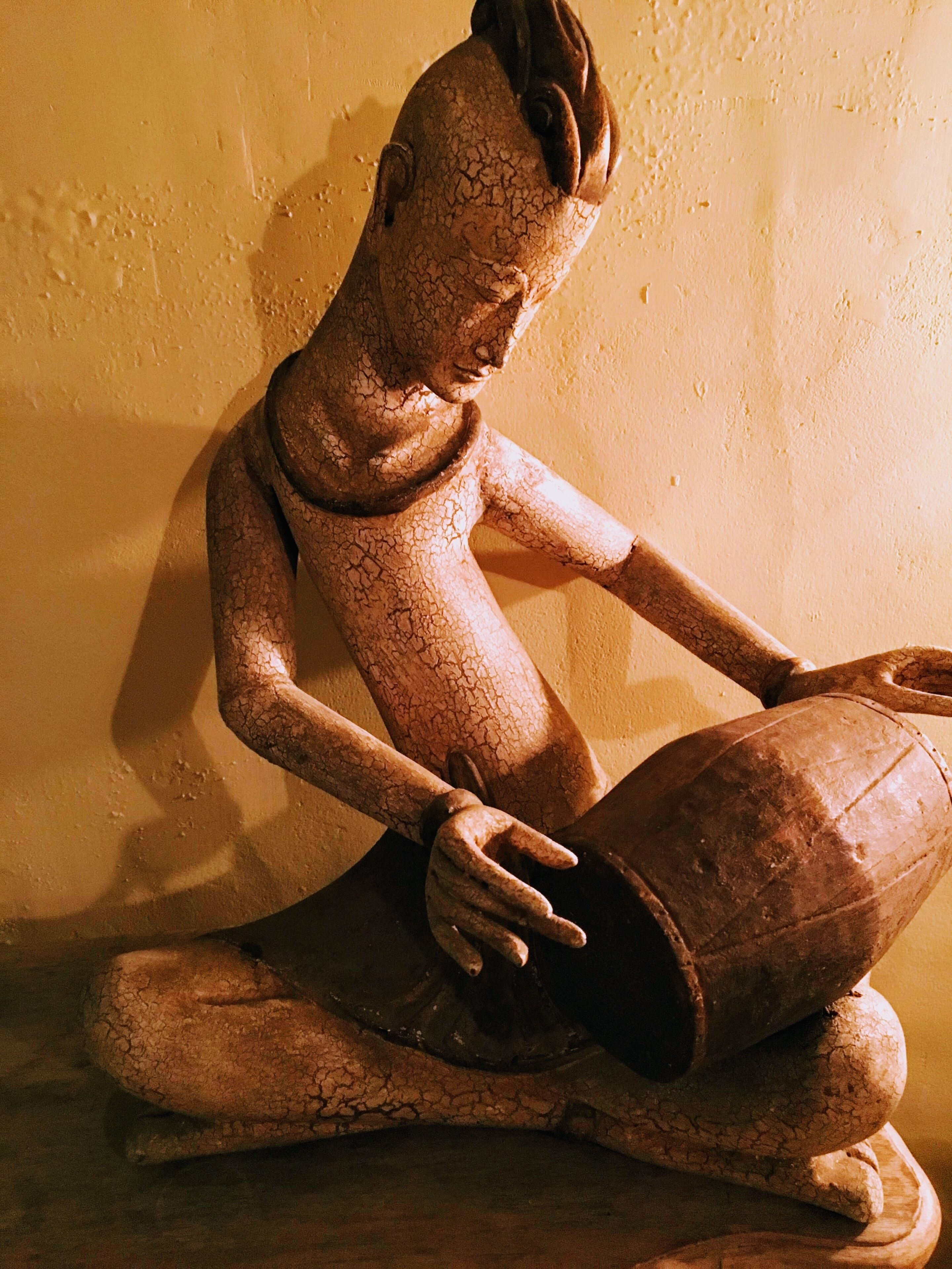 Una escultura de una figura sentada con un cuenco.