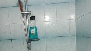 A bathroom with a shower, a bathtub, and a shelf with toiletries. - The Best Rooms 2 (Hospitalet de Llobregat 1 - 2)