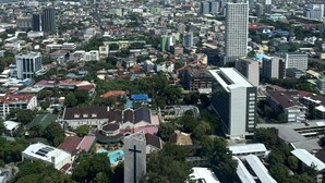 Panorama urbano con un ponte ben visibile sullo sfondo, diversi edifici e un'ampia distesa d'acqua.