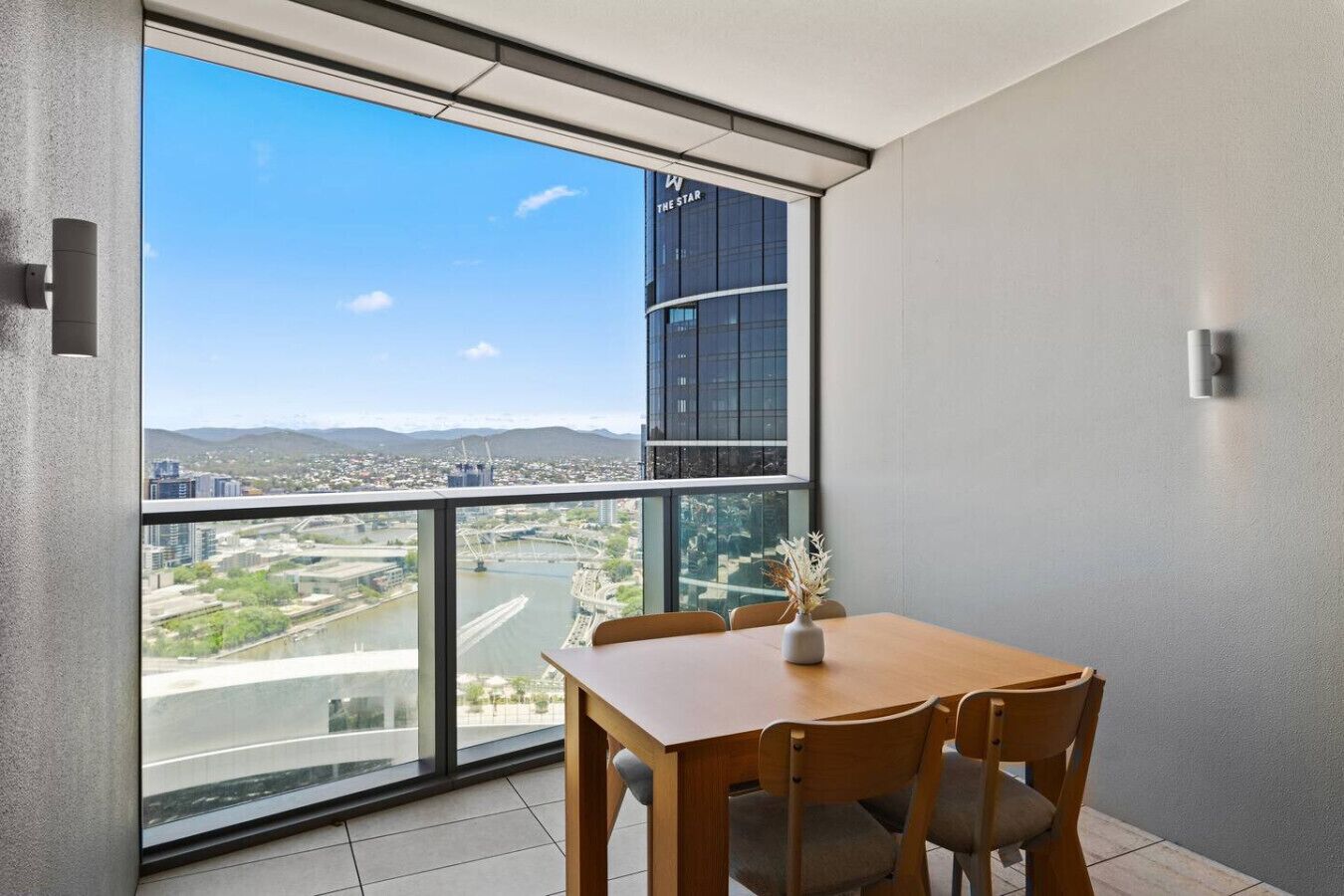 Ein modernes Zimmer mit einem großen Fenster und Blick auf eine Stadtlandschaft sowie einen Fluss.