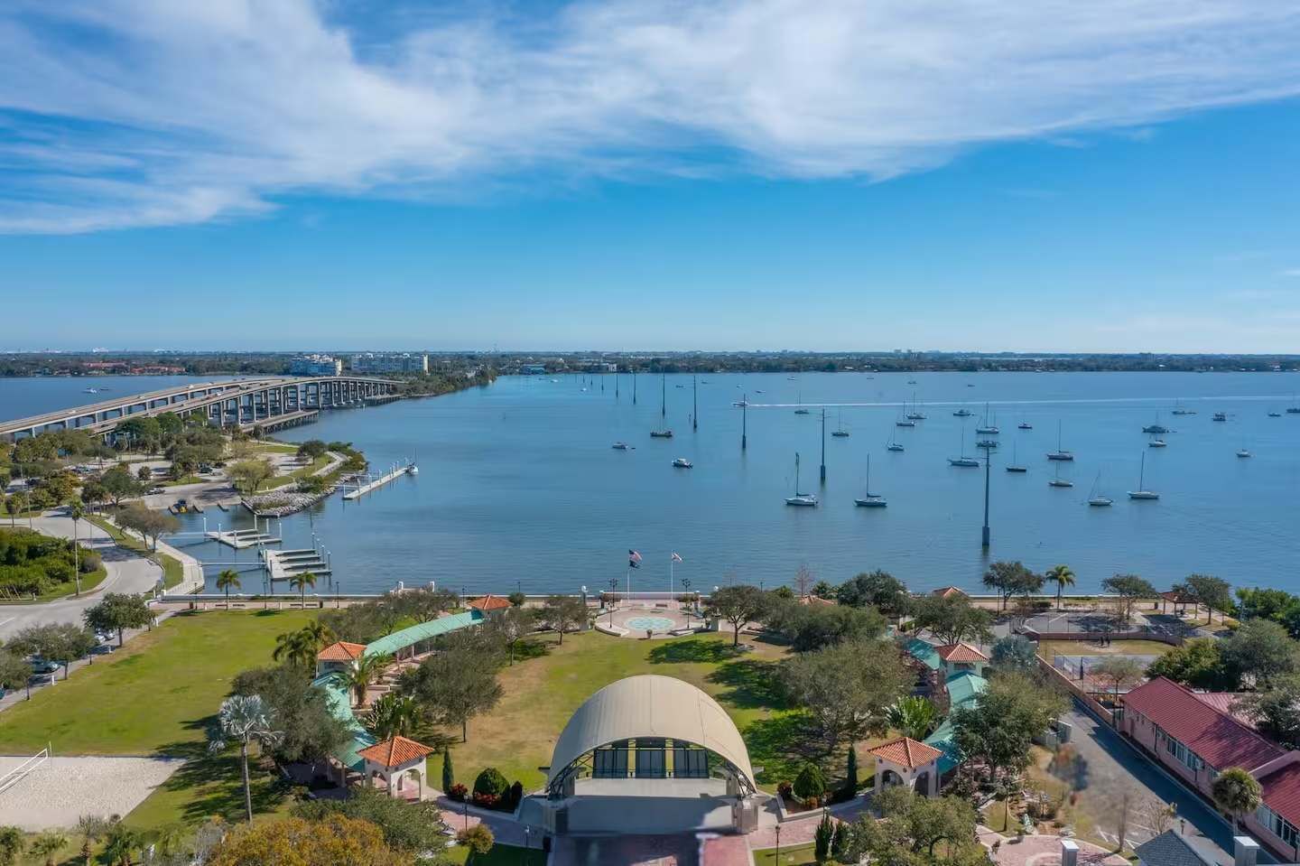 A coastal area with a marina, a bridge, and a large building with a dome.