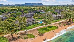 A resort with multiple buildings, a swimming pool, and a beach with clear waters. - Beautiful OCEAN VIEW with free Parking & Top Floor (Kapaʻa)