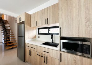 A modern kitchen with wooden cabinets, a stainless steel refrigerator, a sink, and a built-in microwave. - Tropical Oasis in Bayahibe with Pool and Private Terrace with Jacuzzi and BBQ! (Bayahíbe)