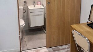 Une salle de bain moderne avec des toilettes, un lavabo et un miroir.