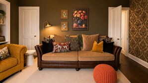 A living room with a brown leather sofa, a round orange ottoman, and a beige rug. - The Yellow Door, Inverness (Inverness)