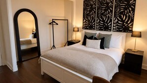 A bedroom with a bed, two bedside tables, a floor lamp, a mirror, and a decorative wall panel. - The Yellow Door, Inverness (Inverness)