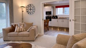 A living room with a sofa, a coffee table, and a clock on the wall. - Ness Gardens, Inverness (Inverness)